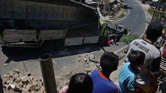 Warga melihat proses evakuasi truk pengangkut susu kemasan yang terguling di Nagreg, Kabupaten Bandung, Jawa Barat, Selasa (25/8/2020).  [ANTARA FOTO/Candra Yanuarsyah]