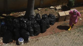 Tim medis mengemas sampah medis di Gelanggang Olahraga Remaja (GOR) Tambora, Jakarta, Rabu (26/8/2020). [Suara.com/Angga Budhiyanto]