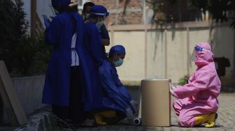 Tim medis mengemas sampah medis di Gelanggang Olahraga Remaja (GOR) Tambora, Jakarta, Rabu (26/8/2020). [Suara.com/Angga Budhiyanto]