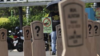 Aktivis buruh yang tergabung dalam Serikat Buruh Migran Indonesia (SBMI) dan Greenpeace Indonesia membawa poster saat melakukan aksi damai di depan Istana Merdeka, Jakarta, Kamis (27/8/2020). [Suara.com/Angga Budhiyanto]