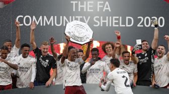 Pemain Arsenal merayakan sukses merebut trofi Community Shield ketika event yang menjadi pembuka musim baru dimainkan di Wembley Stadium, London, Sabtu (29/8).  [ANDREW COULDRIDGE / POOL / AFP]