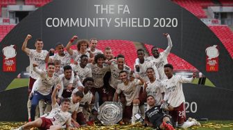 Pemain Arsenal merayakan sukses merebut trofi Community Shield ketika event yang menjadi pembuka musim baru dimainkan di Wembley Stadium, London, Sabtu (29/8).  [ANDREW COULDRIDGE / POOL / AFP]