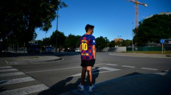 Fans cilik Barcelona menunggu di luar Ciutat Esportiva Joan Gamper, Barcelona, Spanyol, Minggu (30/8). [PAU BARRENA / AFP]