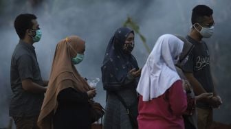 Keluarga jenazah pasien COVID-19 memanjatkan doa di TPU Pondok Ranggon, Jakarta, Rabu (2/9/2020). [Suara.com/Angga Budhiyanto]