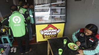 Sejumlah pengemudi ojek online mengantre untuk menikmati hidangan makan gratis di Warung Makan Rakyat, Beji, Depok, Jawa Barat, Kamis (3/9/2020). [Suara.com/Angga Budhiyanto]