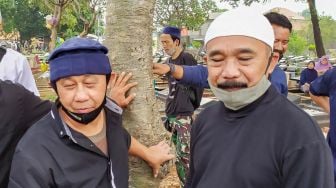 Komedian Opie Kumis turut mengahidiri pemakaman Achmad Sahidan atau Idan Separo di TPU Poncol, Bekasi, Jawa Barat, Kamis (3/9). [Suara.com/Alfian Winanto]