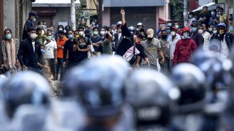 Sejumlah warga melempar batu selama bentrokan dengan polisi setelah pihak berwenang berusaha menghentikan prosesi kereta Buddha tahunan Rato Machindranath di Lalitpur, Nepal (3/9/2020). [PRAKASH MATHEMA / AFP]