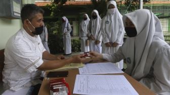 Sejumlah pelajar mengambil kartu perdana yang dibagikan di SMK Negeri 8 Jakarta, Jumat (4/9/2020). [Suara.com/Angga Budhiyanto]