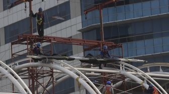 Sejumlah pekerja menyelesaikan pembangunan atap Stasiun Light Rail Transit (LRT) Jabodebek lintas pelayanan dua Cawang-Dukuh Atas di Jakarta, Sabtu (5/9/2020). [Suara.com/Angga Budhiyanto]