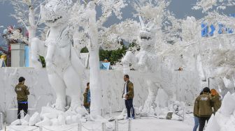 Pengunjung berfoto di depan patung yang terbuat dari pasir putih yang menyerupai es di taman "Frost Magical Ice of Siam" di luar Pattaya, Thailand (2/9/2020). [Mladen ANTONOV / AFP]