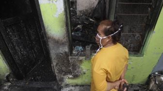 Seorang warga mengamati sisa kebakaran yang melanda permukiman di Kelurahan Bali Mester, Kecamatan Jatinegara, Jakarta, Selasa (8/9/2020). [Suara.com/Angga Budhiyanto]