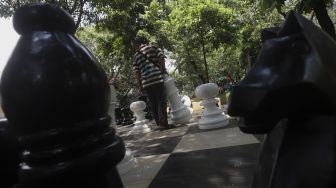 Warga bermain catur raksasa di sela-sela waktu istirahatnya di Taman Danau Singkarak, Bendungan Hilir, Jakarta, Rabu (9/9/2020). [Suara.com/Angga Budhiyanto]
