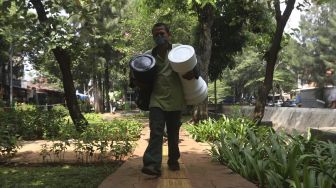 Petugas Sudin Pertamanan dan Kehutanan Jakarta Pusat membawa bidak catur raksasa di Taman Danau Singkarak, Bendungan Hilir, Jakarta, Rabu (9/9/2020). [Suara.com/Angga Budhiyanto]