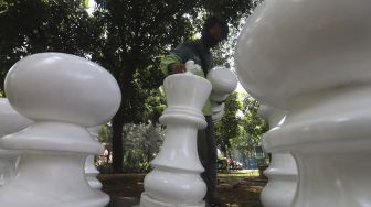 Petugas Sudin Pertamanan dan Kehutanan Jakarta Pusat menata bidak catur raksasa di Taman Danau Singkarak, Bendungan Hilir, Jakarta, Rabu (9/9/2020). [Suara.com/Angga Budhiyanto]