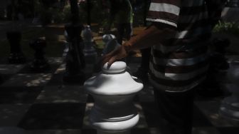 Petugas Sudin Pertamanan dan Kehutanan Jakarta Pusat bersama warga bermain catur raksasa di sela-sela waktu istirahatnya di Taman Danau Singkarak, Bendungan Hilir, Jakarta, Rabu (9/9/2020). [Suara.com/Angga Budhiyanto]