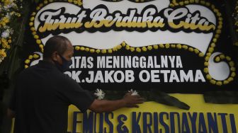 Petugas merapikan karangan bunga tanda berduka cita atas meninggalnya almarhum Pendiri Kompas Gramedia/ Pemimpin Umum Harian Kompas Jakob Oetama di rumah duka di jalan Sriwijaya, Jakarta, Rabu (9/9/2020). [Suara.com/Angga Budhiyanto]