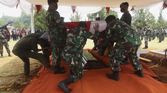 Peronel TNI membentangkan bendera Merah Putih di atas peti jenazah Pendiri Kompas Gramedia/Pemimpin Umum Harian Kompas Jakob Oetama di Taman Makam Pahlawan (TMP) Kalibata, Jakarta, Kamis (10/9/2020). [Suara.com/Angga Budhiyanto]