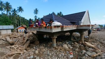 Sejumlah bocah makan di atas atap rumah usai bencana banjir dan tanah longsor di Desa Mamungaa Timur, Kecamatan Bulawa, Kabupaten Bone Bolango, Gorontalo, Kamis (10/9/2020). [ANTARA FOTO/Adiwinata Solihin]