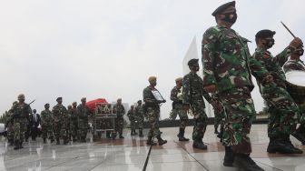 Peronel TNI mengusung peti jenazah Pendiri Kompas Gramedia/Pemimpin Umum Harian Kompas Jakob Oetama menuju liang lahat setibanya di Taman Makam Pahlawan (TMP) Kalibata, Jakarta, Kamis (10/9/2020). [Suara.com/Angga Budhiyanto]