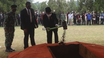 Mantan Wakil Presiden Indonesia Muhammad Jusuf Kalla menimbunkan tanah ke liang lahat saat prosesi pemakaman Pendiri Kompas Gramedia/Pemimpin Umum Harian Kompas Jakob Oetama di Taman Makam Pahlawan (TMP) Kalibata, Jakarta, Kamis (10/9/2020). [Suara.com/Angga Budhiyanto]