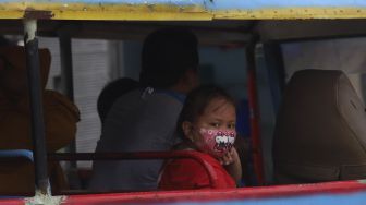 Seorang anak menggunakan masker saat menaiki odong-odong di kawasan Jatinegara, Jakarta, Jumat (11/9/2020). [Suara.com/Angga Budhiyanto]