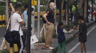 Warga menggunakan masker saat melintas di kawasan Kebon Melati, Jakarta Pusat, Jumat (11/9/2020). [Suara.com/Angga Budhiyanto]