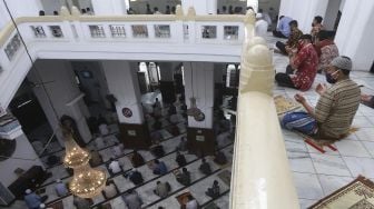 Sejumlah umat Muslim memanjatkan doa saat melaksanakan ibadah Shalat Jumat secara berjamaah di Masjid Cut Meutia, Jakarta, Jumat (11/9/2020). [Suara.com/Angga Budhiyanto]