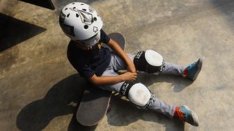 Seorang anak beristirahat disela-sela waktu berlatih skateboard di Crooz School of Skate di kawasan Duren Tiga, Jakarta, Sabtu (12/9/2020). [Suara.com/Angga Budhiyanto]