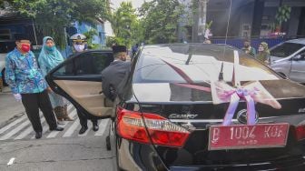 Pengantin menggunakan mobil dinas Pemerintah Kota Bekasi menuju lokasi pernikahan di Bekasi, Jawa Barat, Sabtu (12/9/2020). [ANTARA FOTO/ Fakhri Hermansyah]