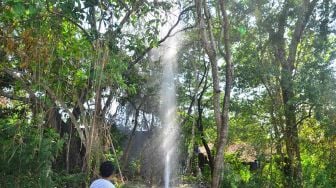 Warga menyaksikan semburan air dari sumur bor di Desa Manggarmas, Godong, Grobogan, Jawa Tengah, Minggu (13/9/2020). [ANTARA FOTO/Yusuf Nugroho]