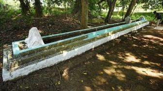 Pekerja membersihkan nisan makam Ki Mas Dawa (Joyo Kusumo) di Kampung Karang Asem, Pancur, Serang, Banten, Minggu (13/9/2020). [ANTARA FOTO/Asep Fathulrahman]