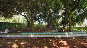 Pekerja membersihkan nisan makam Ki Mas Dawa (Joyo Kusumo) di Kampung Karang Asem, Pancur, Serang, Banten, Minggu (13/9/2020). [ANTARA FOTO/Asep Fathulrahman]