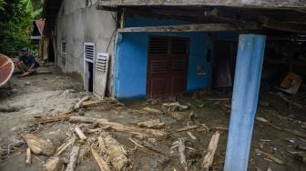 Warga berada di dekat rumahnya yang tertimbun lumpur akibat banjir bandang di Desa Rogo, Kecamatan Dolo Selatan, Kabupaten Sigi, Sulawesi Tengah, Selasa (15/9/2020). [ANTARA FOTO/Basri Marzuki]

