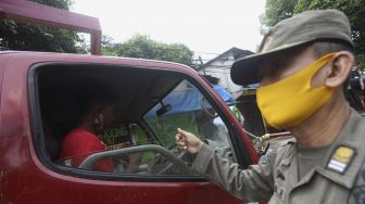 Petugas gabungan Satuan Gugus Tugas Percepatan Penanggulangan Covid-19 menghentikan kendaraan yang pengendaranya tidak mengenakan masker di jalan Taman Margasatwa, Jati padang, Jakarta Selatan, Selasa (15/9/2020). [Suara.com/Angga Budhiyanto]