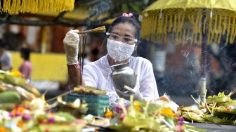 Pemuka agama Hindu memercikkan air suci saat persembahyangan Hari Raya Galungan di Pura Jagatnatha, Denpasar, Bali, Rabu (16/9/2020). [ANTARA FOTO/Fikri Yusuf]
