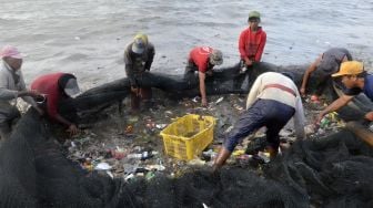 Nelayan memilih ikan hasil tangkapan yang bercampur dengan sampah yang masuk ke dalam jaring di pantai Sukaraja Bandar Lampung, Lampung, Rabu (16/9/2020). [ANTARA FOTO/Ardiansyah] 
