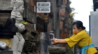 Umat Hindu mencuci tangan saat akan bersembahyang Hari Raya Galungan di Pura Jagatnatha, Denpasar, Bali, Rabu (16/9/2020). [ANTARA FOTO/Fikri Yusuf]
