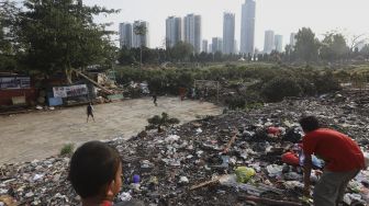 Sejumlah anak bermain dengan latar belakang deretan gedung perkantoran di TPU Menteng Pulo, Jakarta, Rabu (16/9/2020). [Suara.com/Angga Budhiyanto]