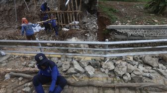 Petugas Suku Dinas Sumber Daya Air Jakarta Selatan membangun kembali turap yang longsor di Rumah Pohon Jagakarsa, Jakarta, Kamis (17/9/2020). [Suara.com/Angga Budhiyanto]