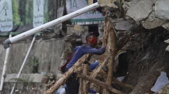 Petugas Suku Dinas Sumber Daya Air Jakarta Selatan membangun kembali turap yang longsor di Rumah Pohon Jagakarsa, Jakarta, Kamis (17/9/2020). [Suara.com/Angga Budhiyanto]