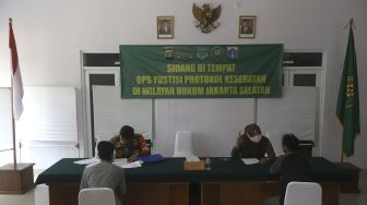 Warga pelanggar PSBB mengikuti sidang di tempat usai terjaring operasi yustisi protokol kesehatan pencegahan Covid-19 di SMKN 57 Jakarta, Kamis (17/9/2020). [Suara.com/Angga Budhiyanto]