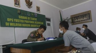 Warga pelanggar PSBB mengikuti sidang di tempat usai terjaring operasi yustisi protokol kesehatan pencegahan Covid-19 di SMKN 57 Jakarta, Kamis (17/9/2020). [Suara.com/Angga Budhiyanto]