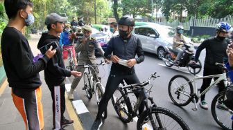 Wali Kota Bogor Bima Arya (tengah) memberikan masker kepada pengguna jalan saat patroli penutupan sementara pedestrian seputaran Istana dan Kebun Raya Bogor, Jawa Barat, Sabtu (19/9/2020).  [ANTARA FOTO/Arif Firmansyah]
