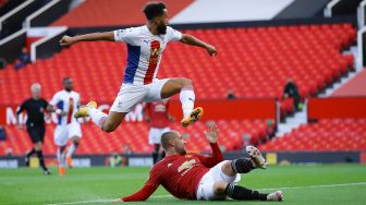 Gelandang Crystal Palace Andros Townsend (kiri) menyaksikan tembakannya masuk untuk gol pembuka saat ia melompati bek Manchester United Luke Shaw selama pertandingan sepak bola Liga Premier Inggris antara Manchester United melawan Crystal Palace di Old Trafford, Manchester, Inggris, Sabtu (19/9). [Richard Heathcote / POOL / AFP]

