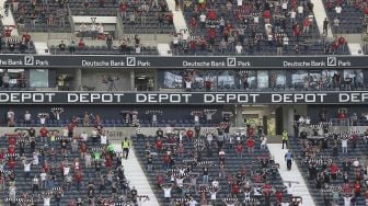 Pendukung Frankfurt bersorak selama pertandingan sepak bola Bundesliga Jerman antara Eintracht Frankfurt melawan Arminia Bielefeld di Frankfurt, Jerman  pada (19/9/2020). [Daniel ROLAND / AFP]