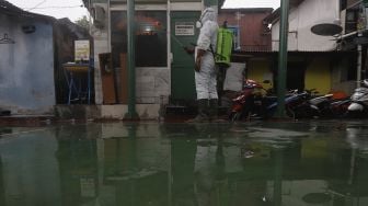 Relawan Siaga Bencana Berbasis Masyarakat (SIBAT) menyemprotkan cairan disinfektan di permukiman padat penduduk di kawasan Menteng Tenggulun, Jakarta, Minggu (20/9/2020). [Suara.com/Angga Budhiyanto]