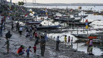 Warga bermain di pesisir pantai batu-batu Kenjeran, Surabaya, Jawa Timur, Minggu (20/9/2020). [ANTARA FOTO/M Risyal Hidayat]