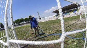 Pekerja menyiram rumput di lapangan Stadion Gelora 10 November di Surabaya, Jawa Timur, Senin (21/9/2020). [ANTARA FOTO/M Risyal Hidayat]