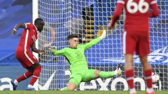 Striker Liverpool Sadio Mane (kiri) mencetak gol kedua mereka melewati kiper Chelsea Kepa Arrizabalaga selama pertandingan sepak bola Liga Utama Inggris antara Chelsea dan Liverpool di Stamford Bridge, London pada (20/9/2020). [NEIL HALL / POOL / AFP]