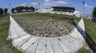 Pekerja merawat rumput di lapangan Stadion Gelora 10 November di Surabaya, Jawa Timur, Senin (21/9/2020). [ANTARA FOTO/M Risyal Hidayat]